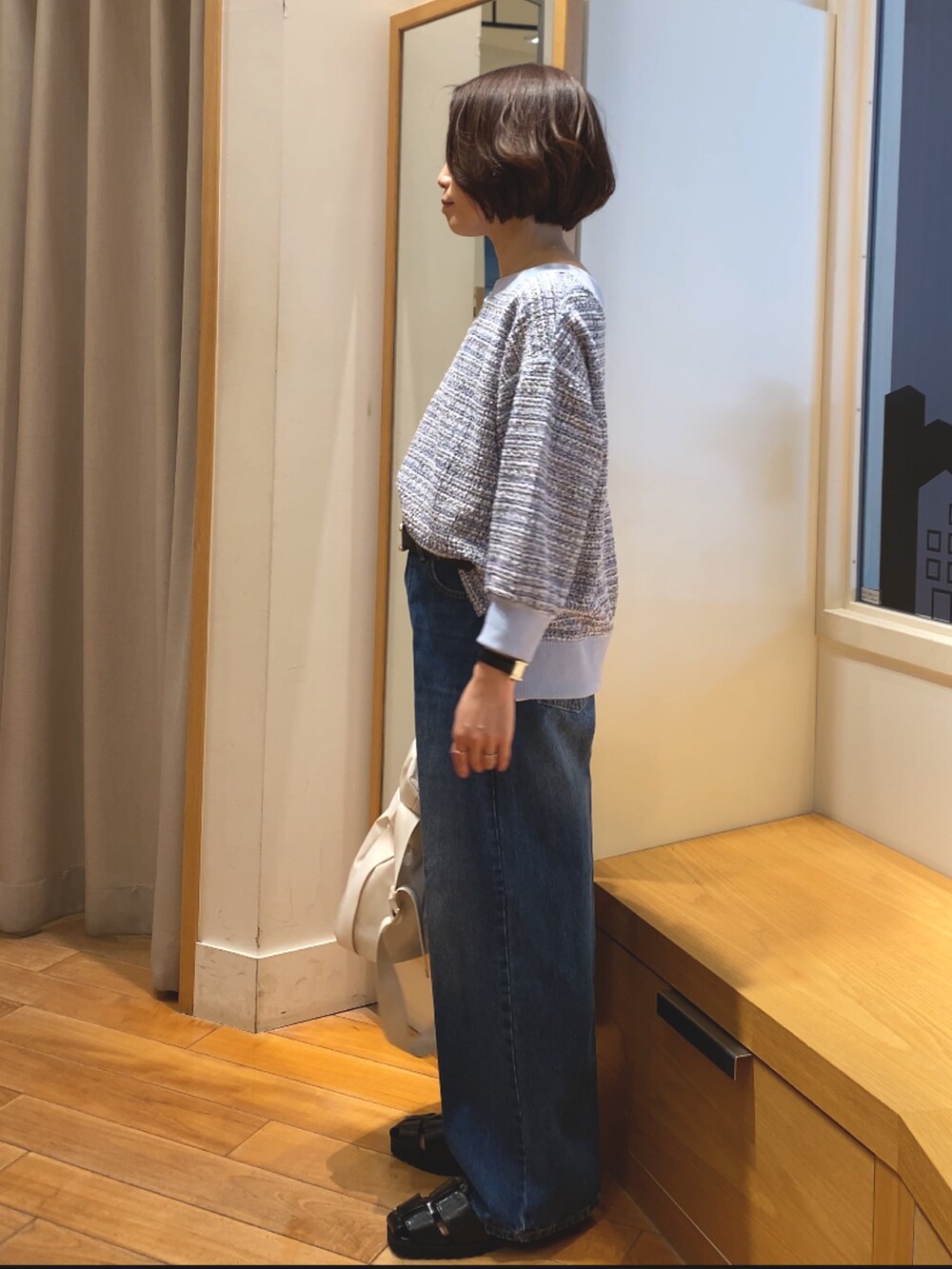 ブルー系のデニムパンツ、ブルー系のTシャツ/カットソー、ホワイト系のショルダーバッグを着用したレディースの春コーディネートの6枚目の写真