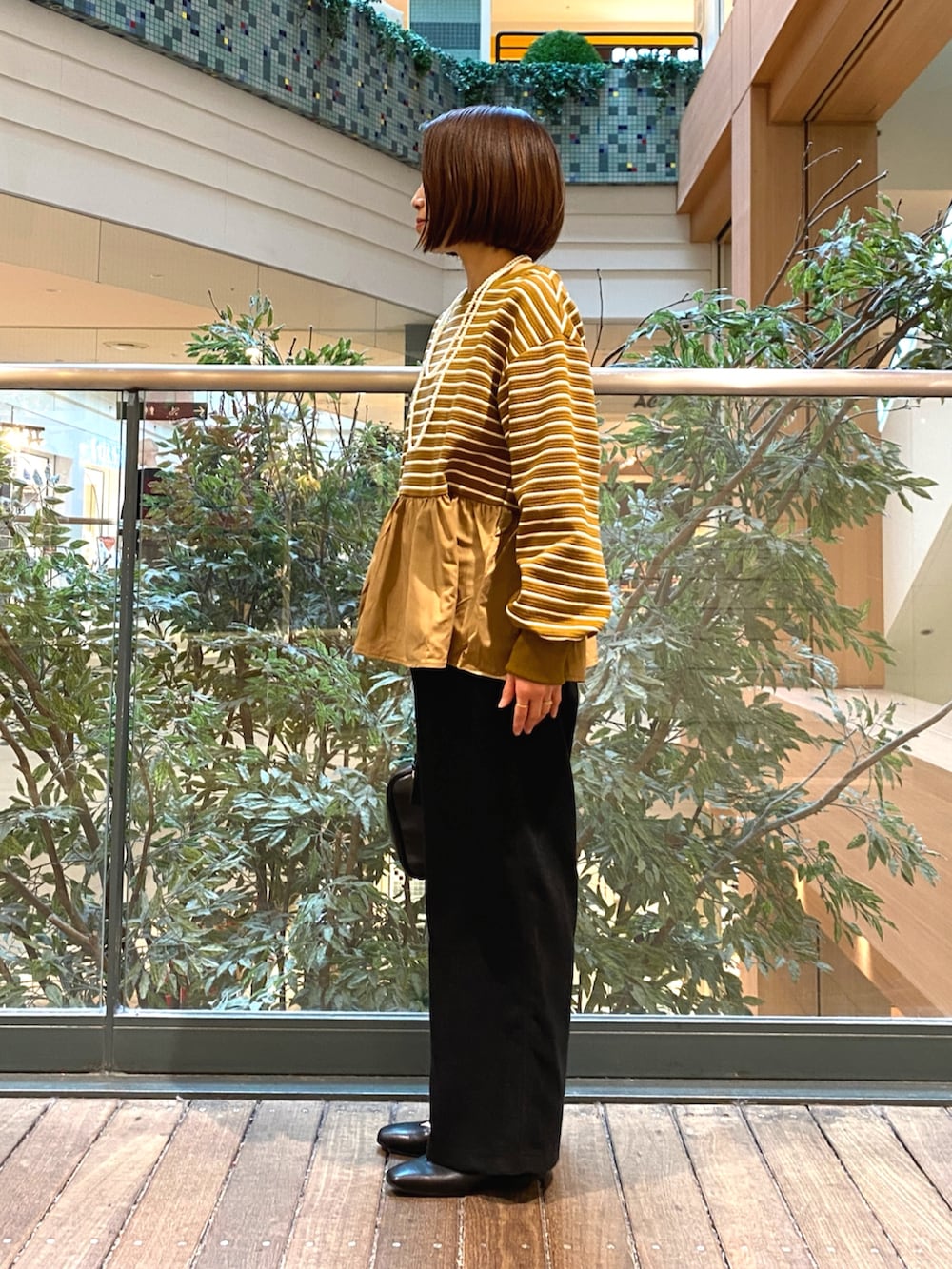 ベージュ系のTシャツ/カットソー、ブラック系のハンドバッグ、ブラック系のその他パンツを着用したレディースの冬コーディネートの3枚目の写真