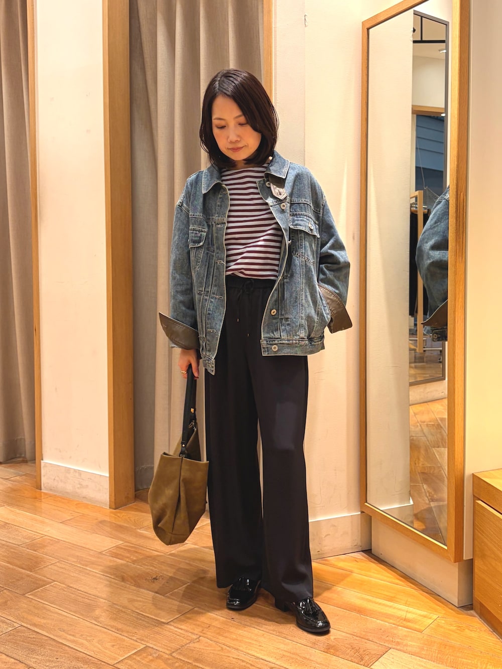 ブラック系のその他パンツ、ブルー系のデニムジャケット、ブルー系のTシャツ/カットソーを着用したレディースの秋コーディネートの4枚目の写真