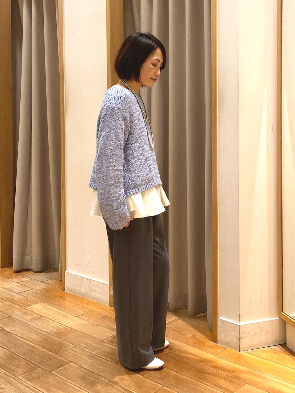 グレー系のその他パンツ、ホワイト系のシャツ/ブラウス、ブルー系のニット/セーターを着用したレディースの春コーディネートの4枚目の写真