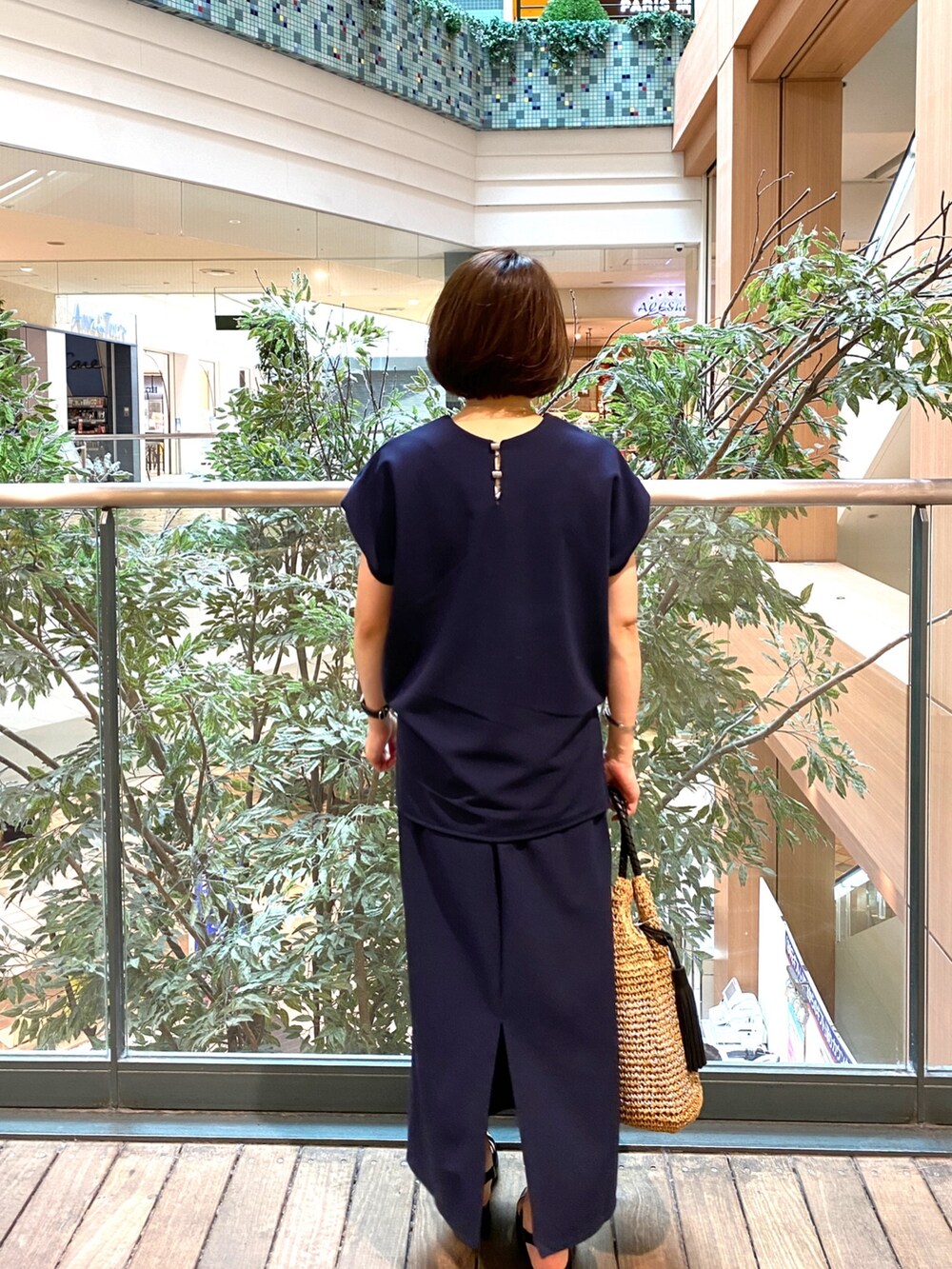 ブルー系のTシャツ/カットソー、ブルー系のスカート、ベージュ系のかごバッグを着用したレディースの夏コーディネートの6枚目の写真