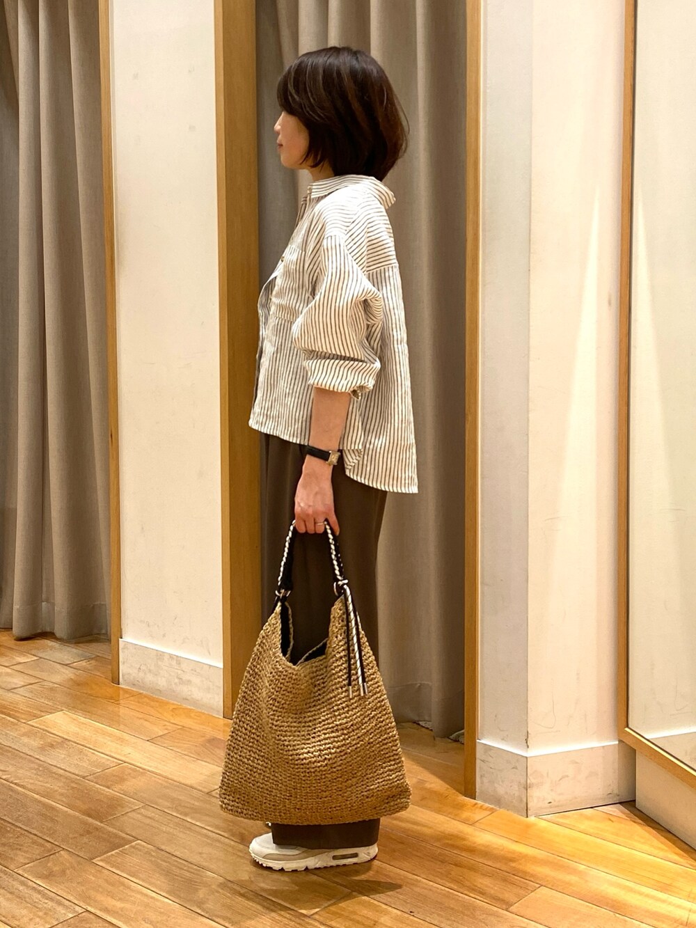 ブラウン系のその他パンツ、ベージュ系のトートバッグ、ベージュ系のシャツ/ブラウスを着用したレディースの春コーディネートの6枚目の写真