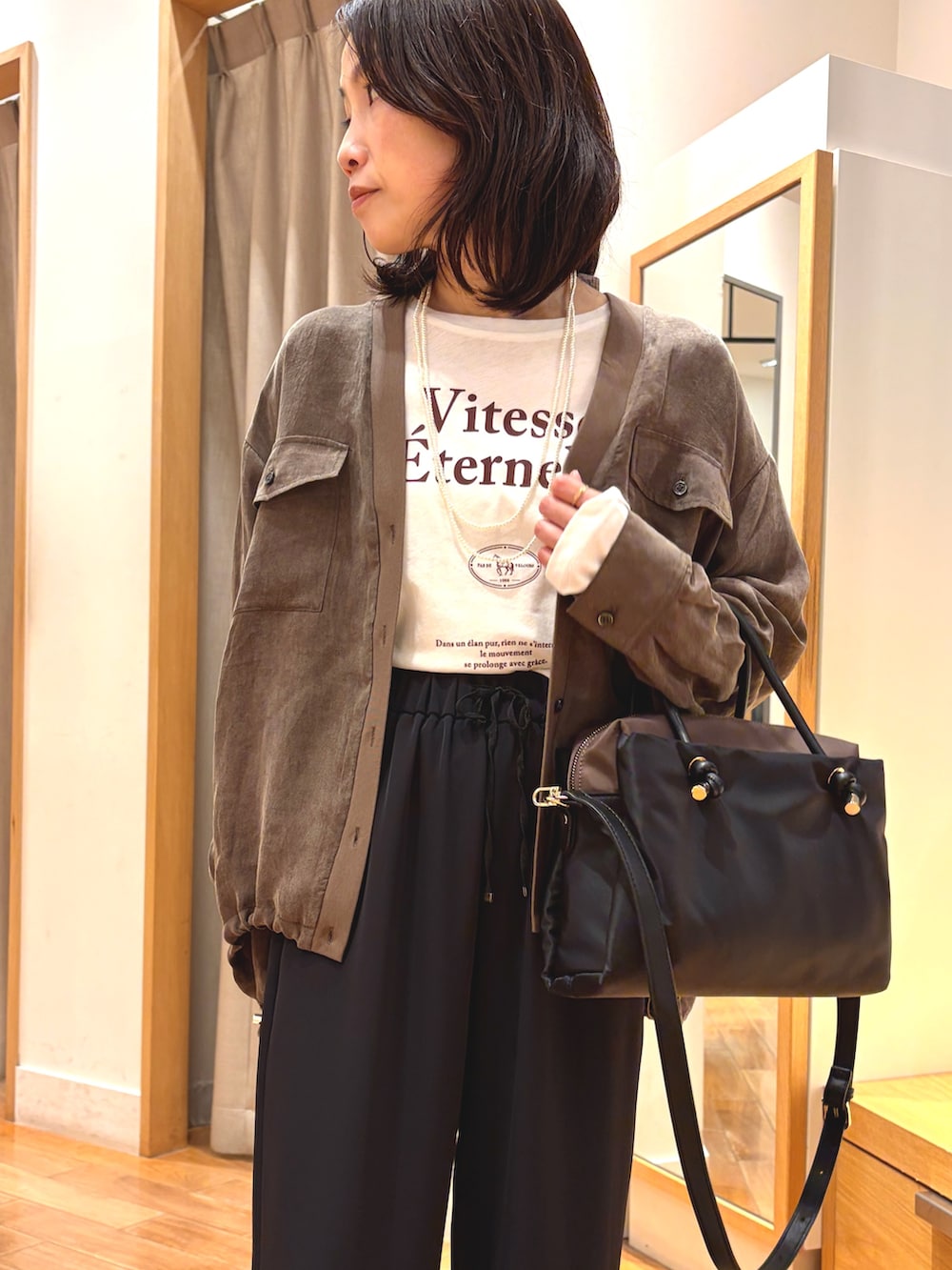 ブラック系のその他パンツ、ホワイト系のTシャツ/カットソー、ブラック系のボストンバッグを着用したレディースの秋コーディネートの3枚目の写真