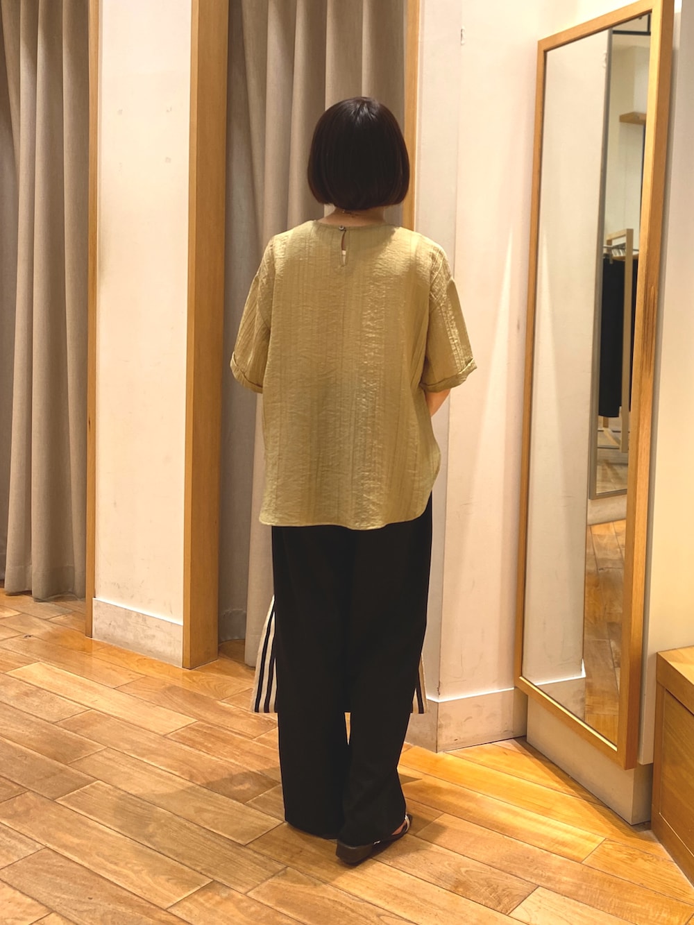 イエロー系のシャツ/ブラウス、グレー系のその他パンツ、ゴールド系のネックレスを着用したレディースの春コーディネートの5枚目の写真