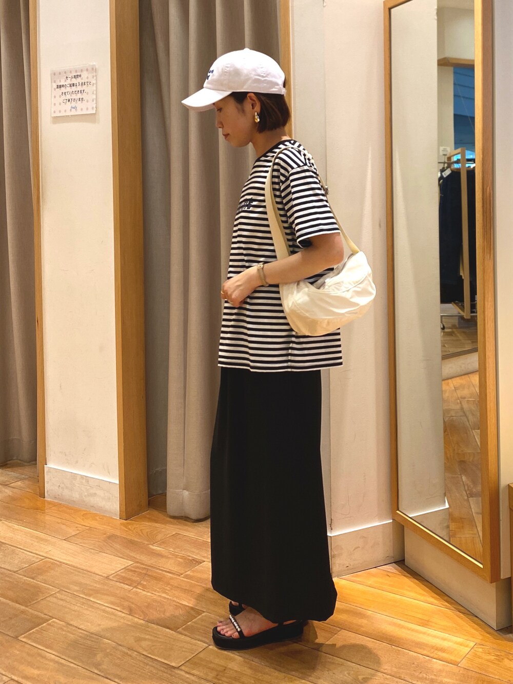 ブラック系のスカート、ホワイト系のTシャツ/カットソー、ホワイト系のショルダーバッグを着用したレディースの夏コーディネートの5枚目の写真