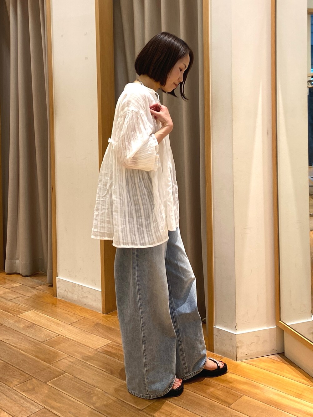 ホワイト系のシャツ/ブラウス、ブラウン系のかごバッグ、ブルー系のデニムパンツを着用したレディースの夏コーディネートの5枚目の写真