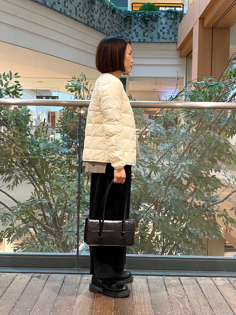 ホワイト系のダウンジャケット/コート、ベージュ系のニット/セーター、ブラック系のTシャツ/カットソーを着用したレディースの冬コーディネートの3枚目の写真