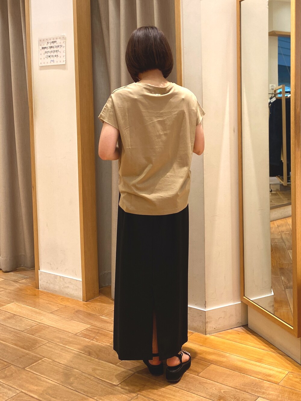 ブラック系のスカート、ブラック系のショルダーバッグ、イエロー系のTシャツ/カットソーを着用したレディースの夏コーディネートの4枚目の写真