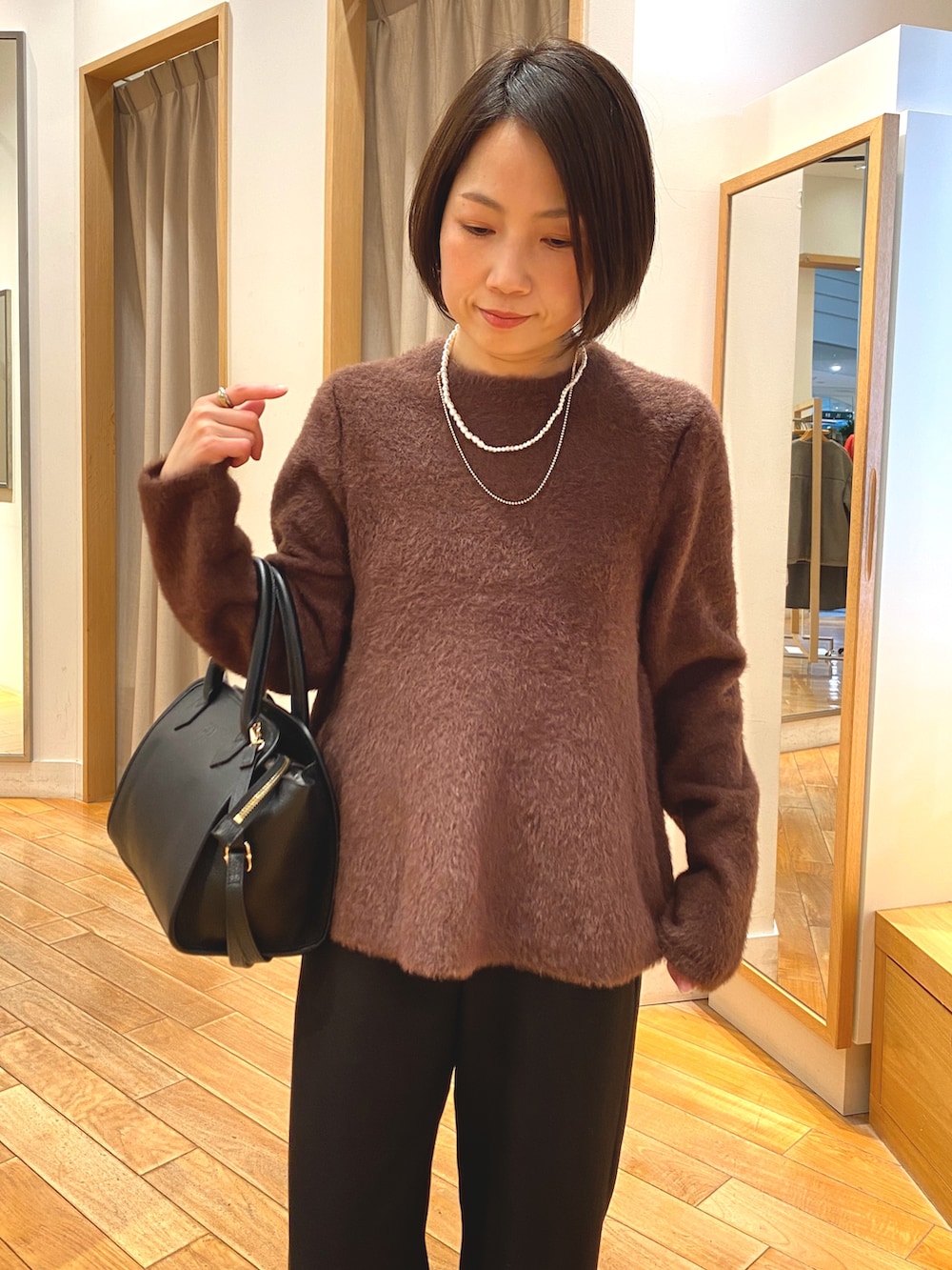 ブラック系のその他パンツ、ブラック系のショルダーバッグ、ブラウン系のニット/セーターを着用したレディースの冬コーディネートの3枚目の写真