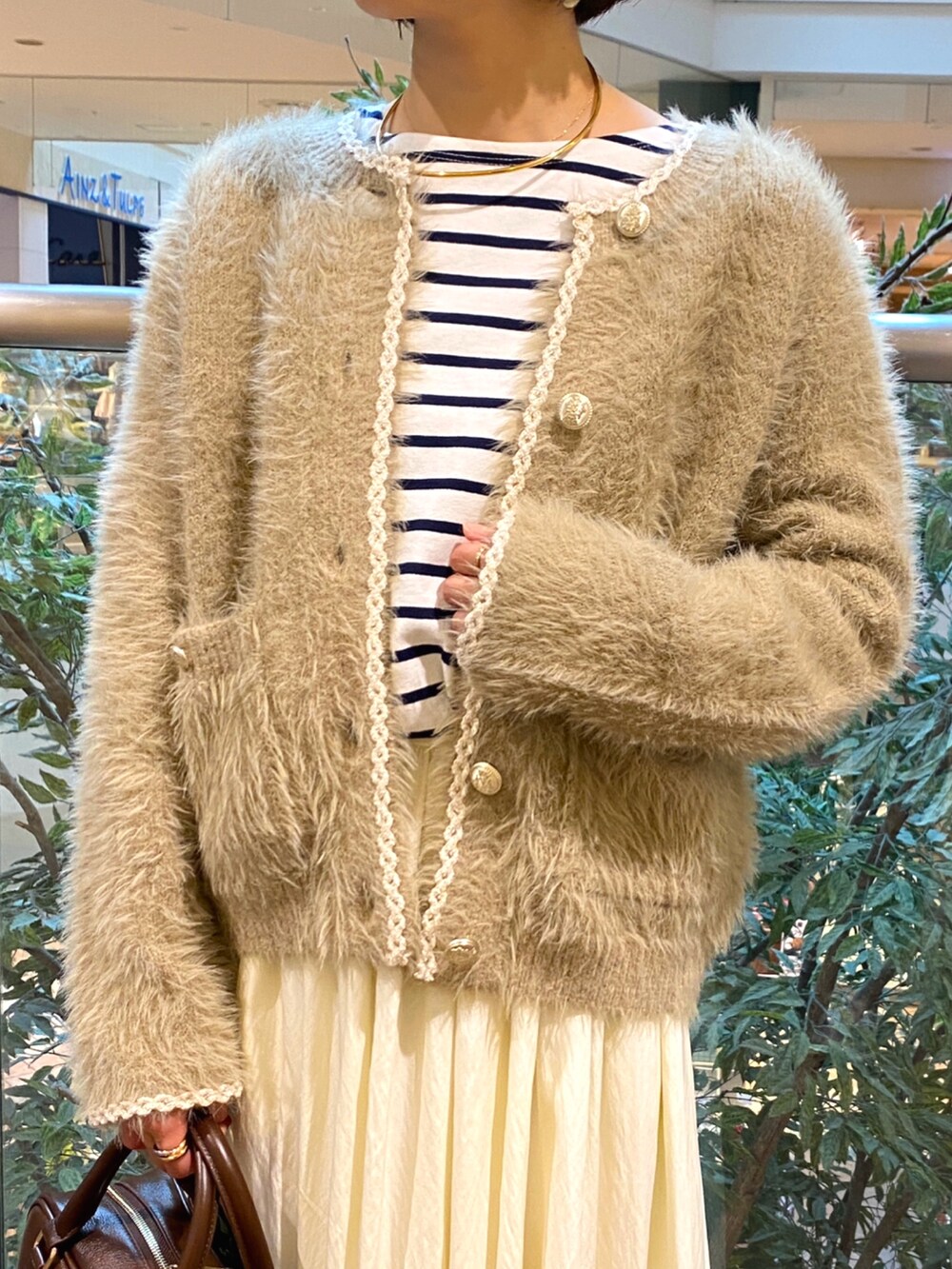 ベージュ系のカーディガン/ボレロ、ホワイト系のTシャツ/カットソー、ホワイト系のスカートを着用したレディースの秋コーディネートの5枚目の写真