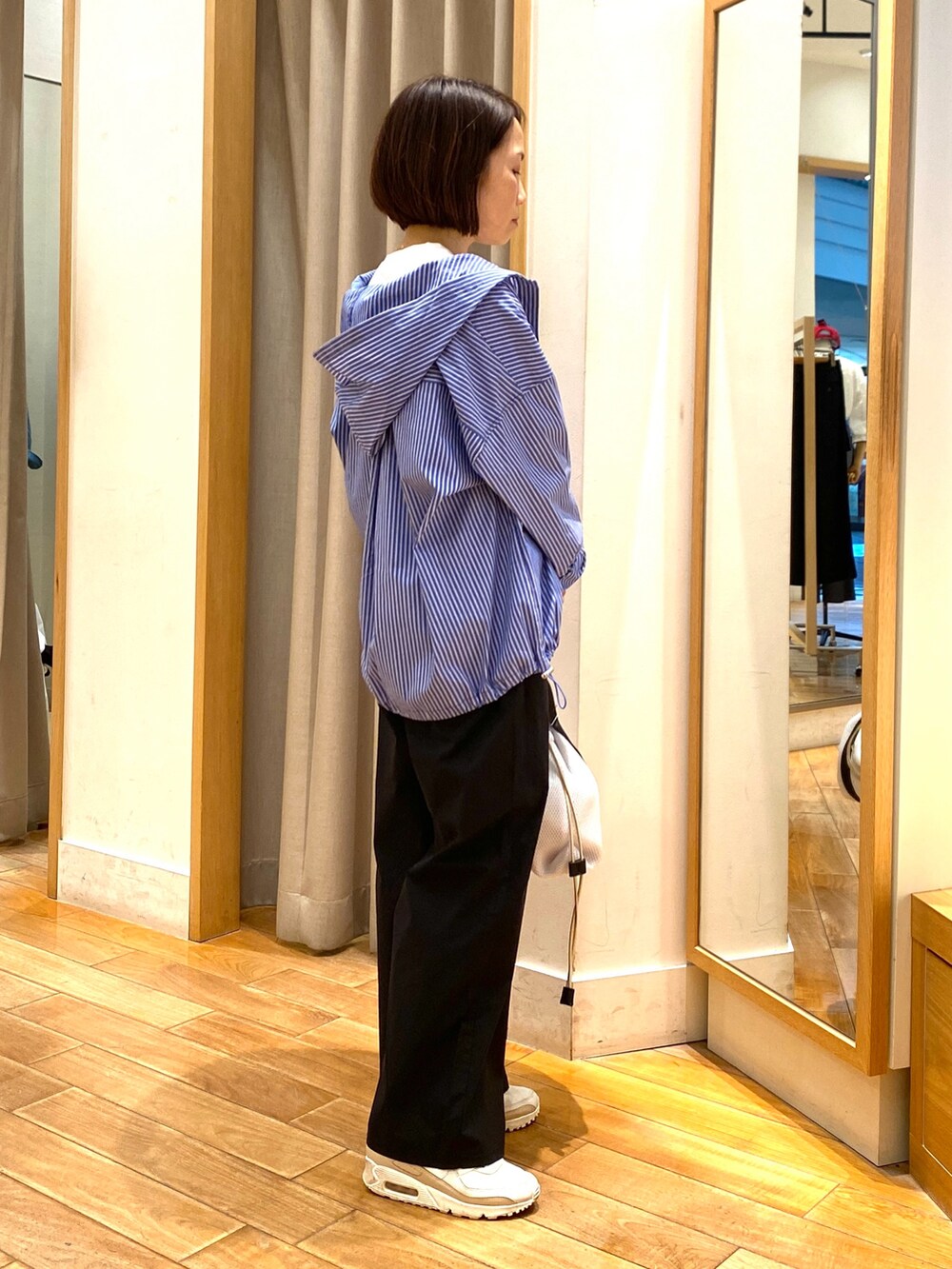 ホワイト系のトートバッグ、ブルー系のシャツ/ブラウス、ホワイト系のTシャツ/カットソーを着用したレディースの春コーディネートの5枚目の写真