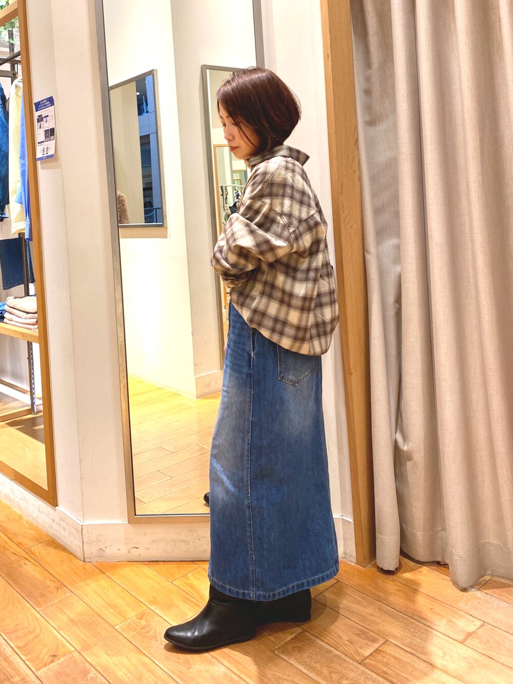 ブラウン系のシャツ/ブラウス、ブルー系のデニムスカート、ブラック系のショルダーバッグを着用したレディースの秋コーディネートの3枚目の写真