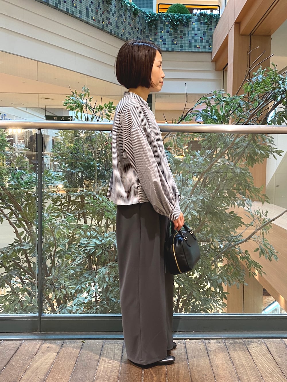 ブルー系のシャツ/ブラウス、ブラック系のハンドバッグ、グレー系のその他パンツを着用したレディースの秋コーディネートの5枚目の写真