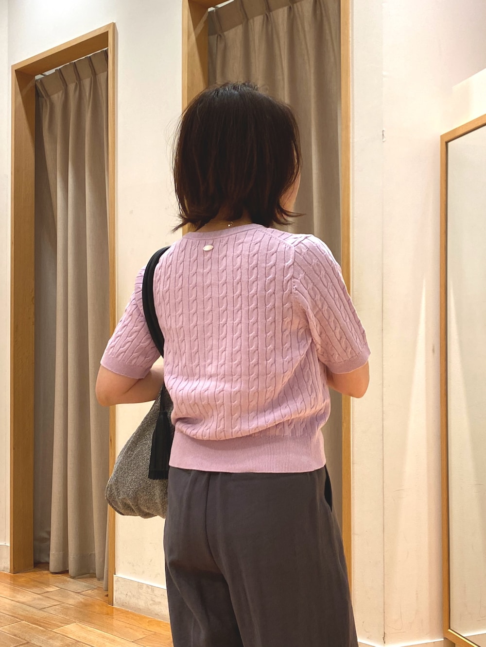 シルバー系のトートバッグ、グレー系のスラックス、パープル系のカーディガン/ボレロを着用したレディースの春コーディネートの8枚目の写真
