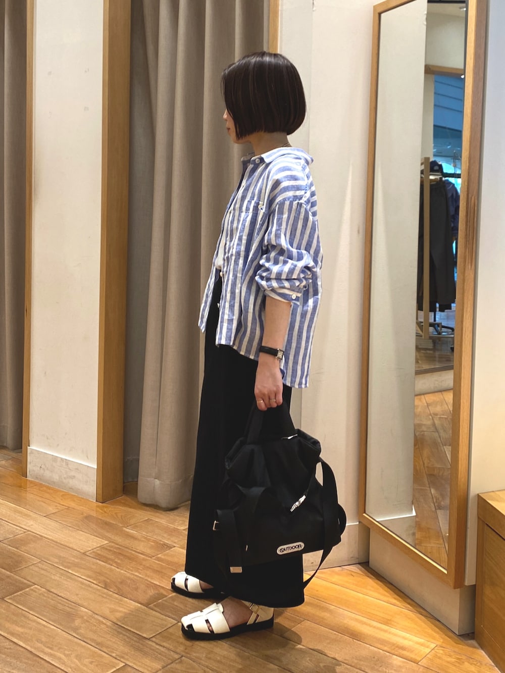ホワイト系のタンクトップ、ブルー系のシャツ/ブラウス、ブラック系のスカートを着用したレディースの春コーディネートの3枚目の写真