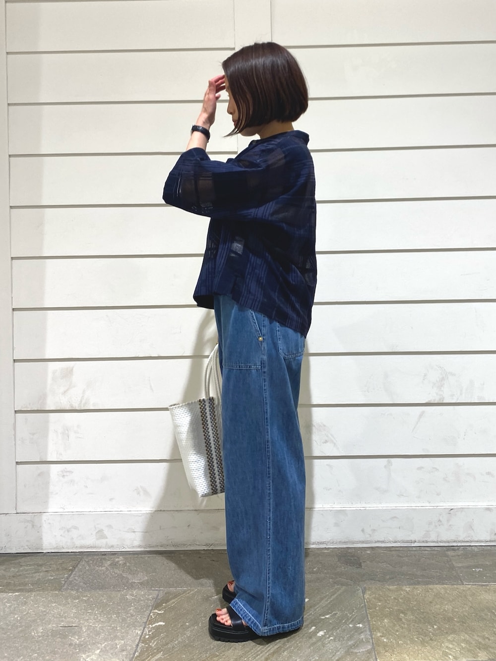 ブルー系のデニムパンツ、ブルー系のシャツ/ブラウス、ホワイト系のタンクトップを着用したレディースの夏コーディネートの4枚目の写真