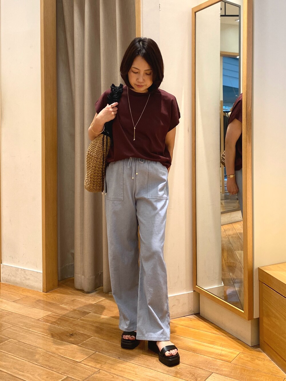ブラウン系のTシャツ/カットソー、ブラック系のショルダーバッグ、ゴールド系のネックレスを着用したレディースの夏コーディネートの2枚目の写真