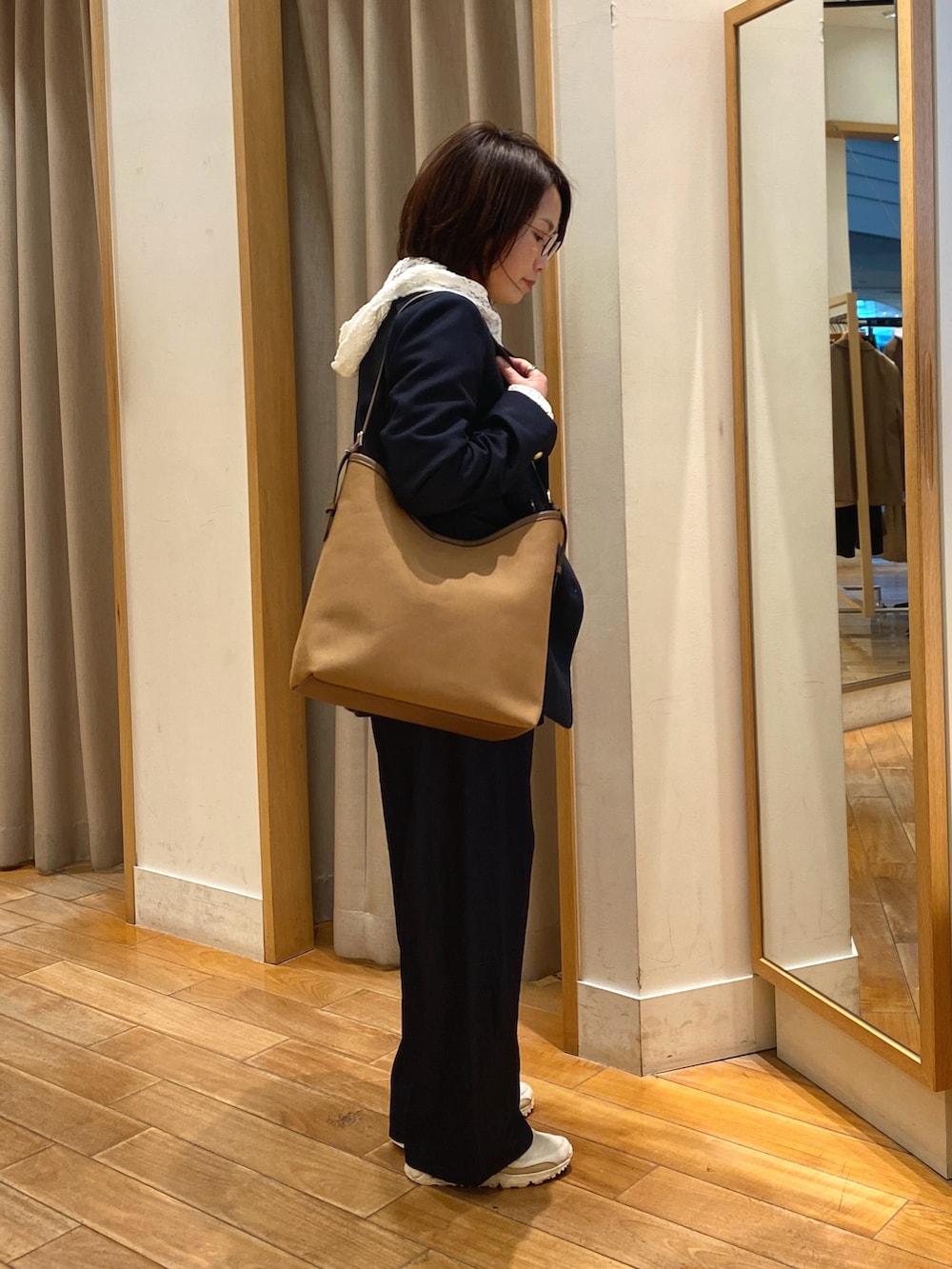 ブラウン系のショルダーバッグ、ホワイト系のTシャツ/カットソー、ブルー系のテーラードジャケットを着用したレディースの春コーディネートの6枚目の写真