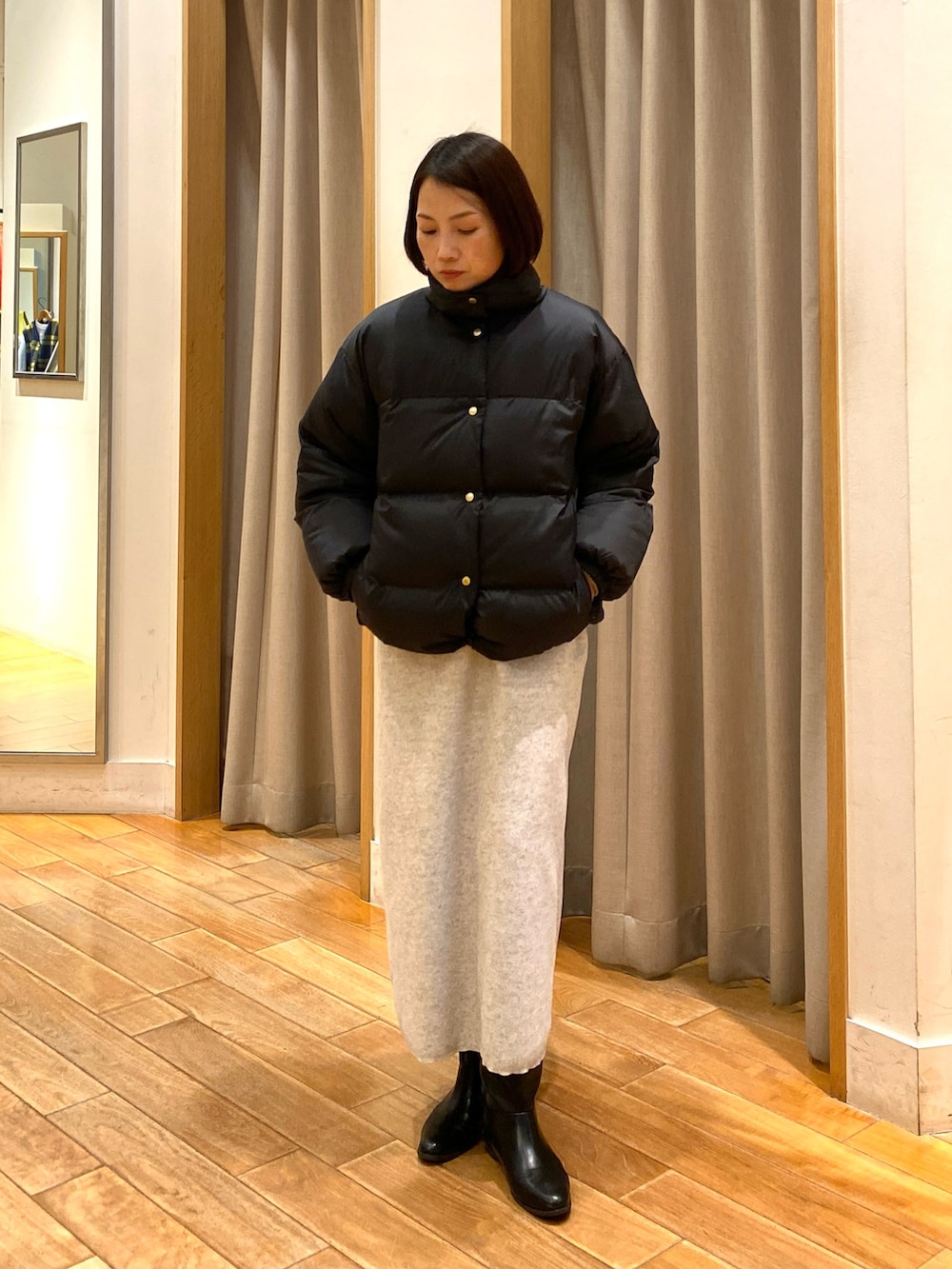 ベージュ系のショルダーバッグ、ブラック系のダウンジャケット/コート、ホワイト系のTシャツ/カットソーを着用したレディースの秋コーディネートの3枚目の写真