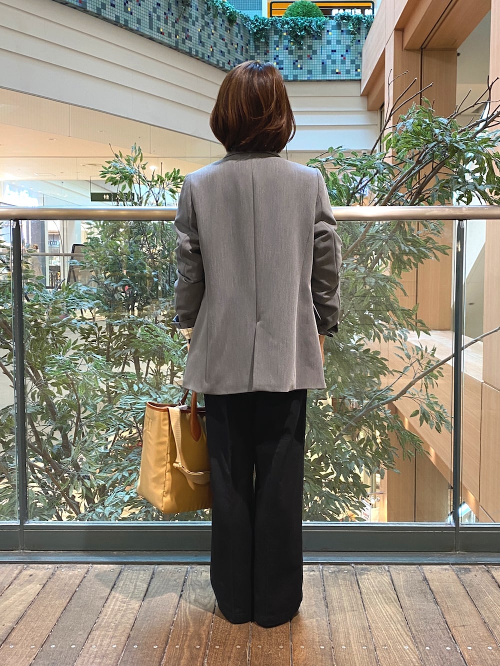 グレー系のテーラードジャケット、ホワイト系のTシャツ/カットソー、ブラック系のチノパンツを着用したレディースの秋コーディネートの7枚目の写真