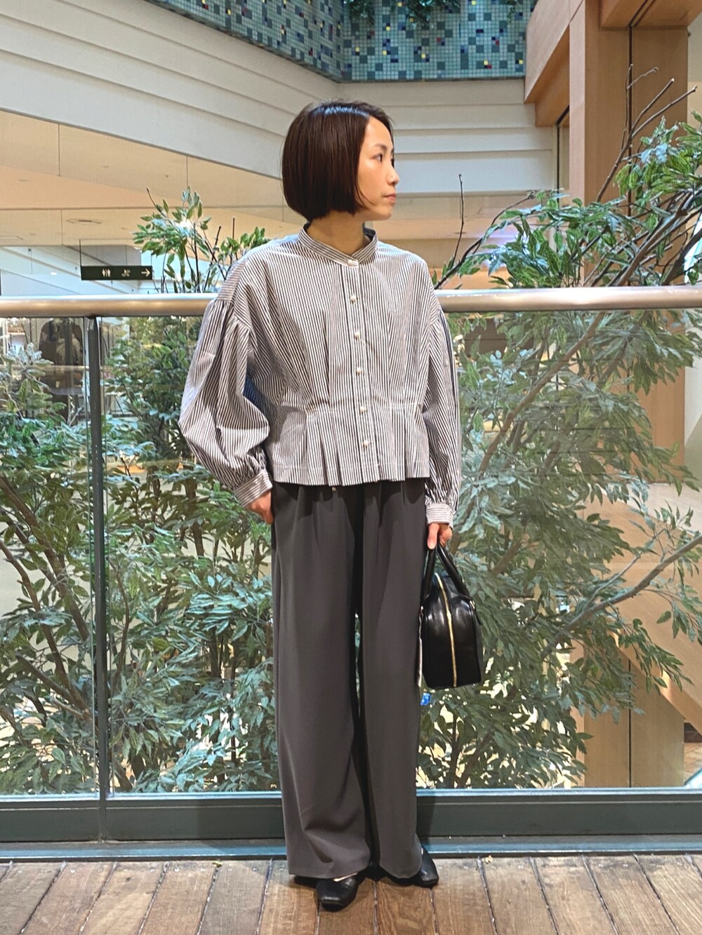 ブルー系のシャツ/ブラウス、ブラック系のハンドバッグ、グレー系のその他パンツを着用したレディースの秋コーディネートの2枚目の写真
