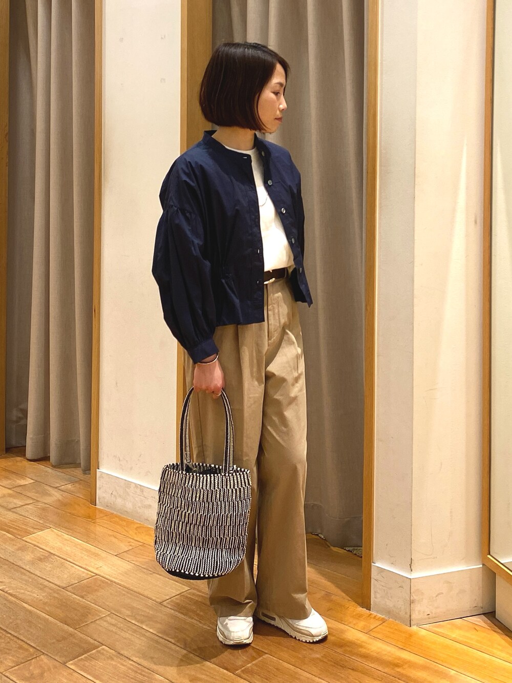 ベージュ系のチノパンツ、ブルー系のシャツ/ブラウス、ホワイト系のTシャツ/カットソーを着用したレディースの春コーディネートの3枚目の写真