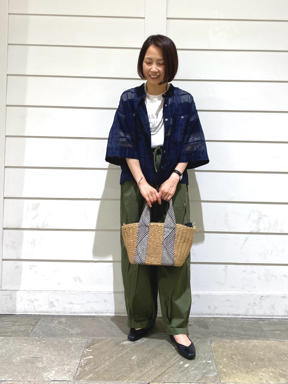 ブルー系のシャツ/ブラウス、グリーン系のその他パンツ、ベージュ系のかごバッグを着用したレディースの夏コーディネートの2枚目の写真