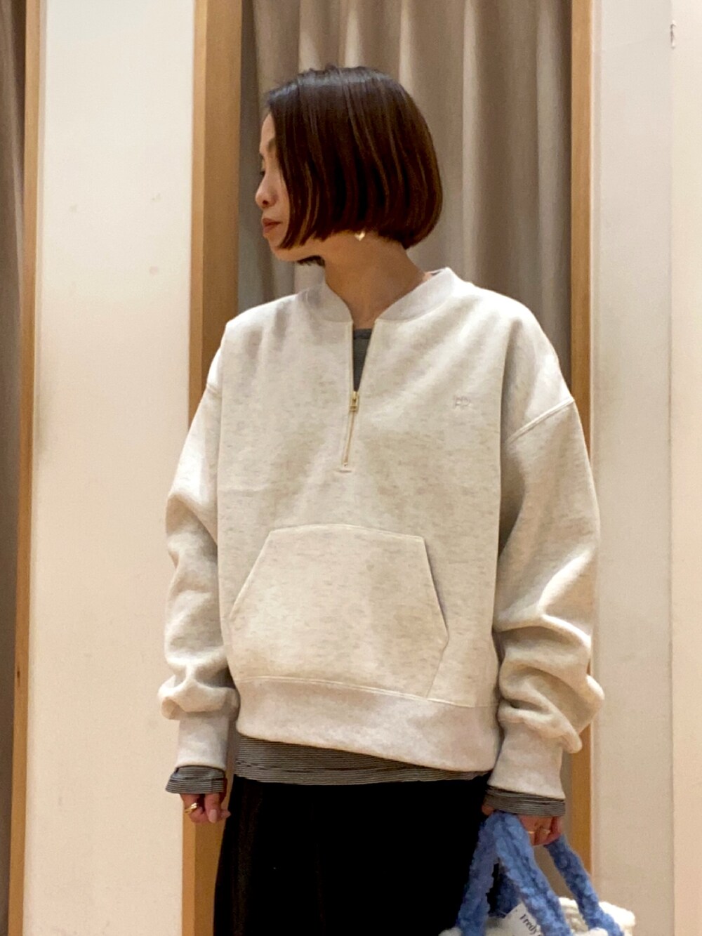 グレー系のスウェット、ブラック系のTシャツ/カットソー、ブラック系のスカートを着用したレディースの冬コーディネートの3枚目の写真