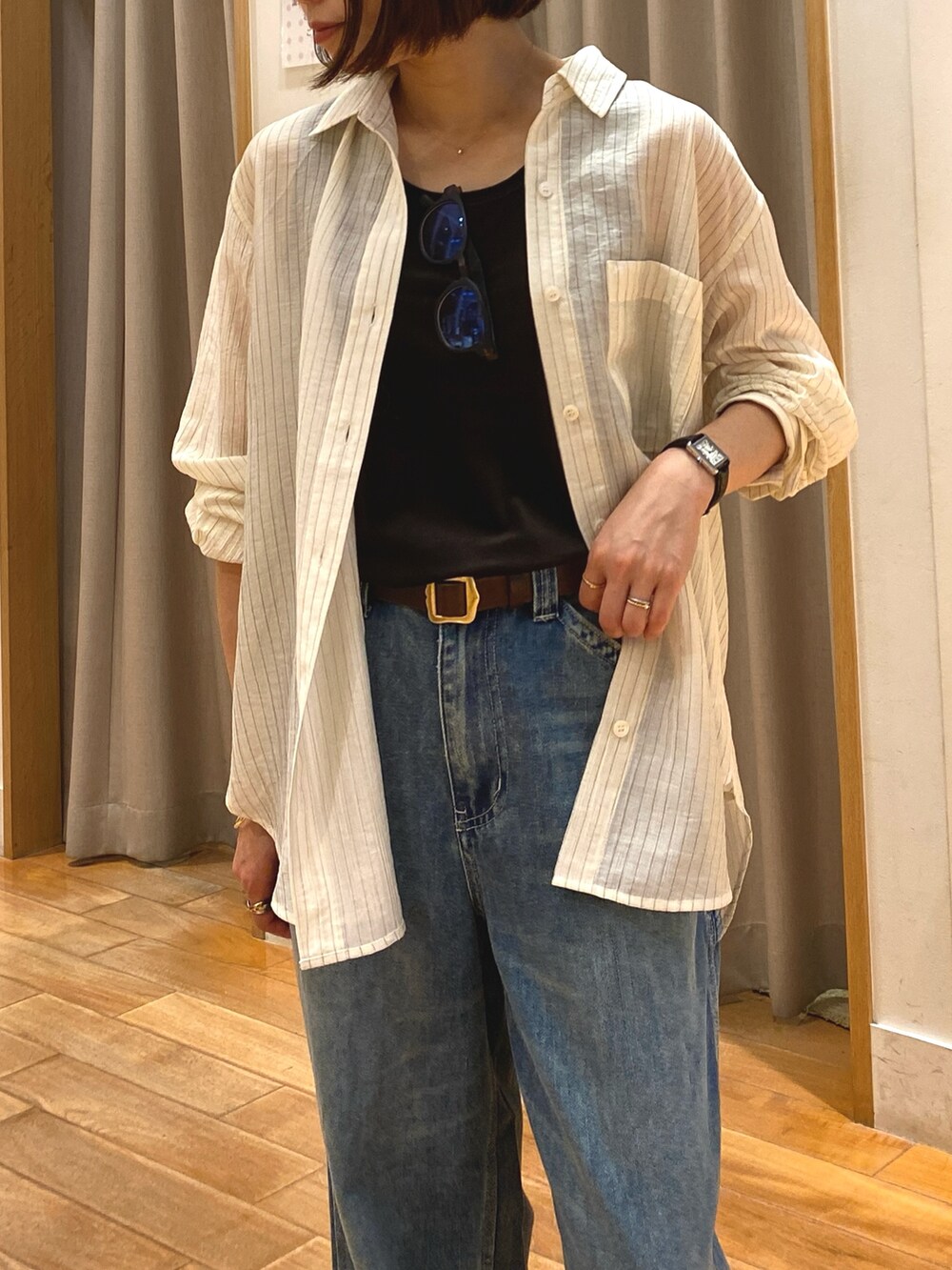 ブルー系のデニムパンツ、ブラック系のショルダーバッグ、ホワイト系のシャツ/ブラウスを着用したレディースの夏コーディネートの4枚目の写真