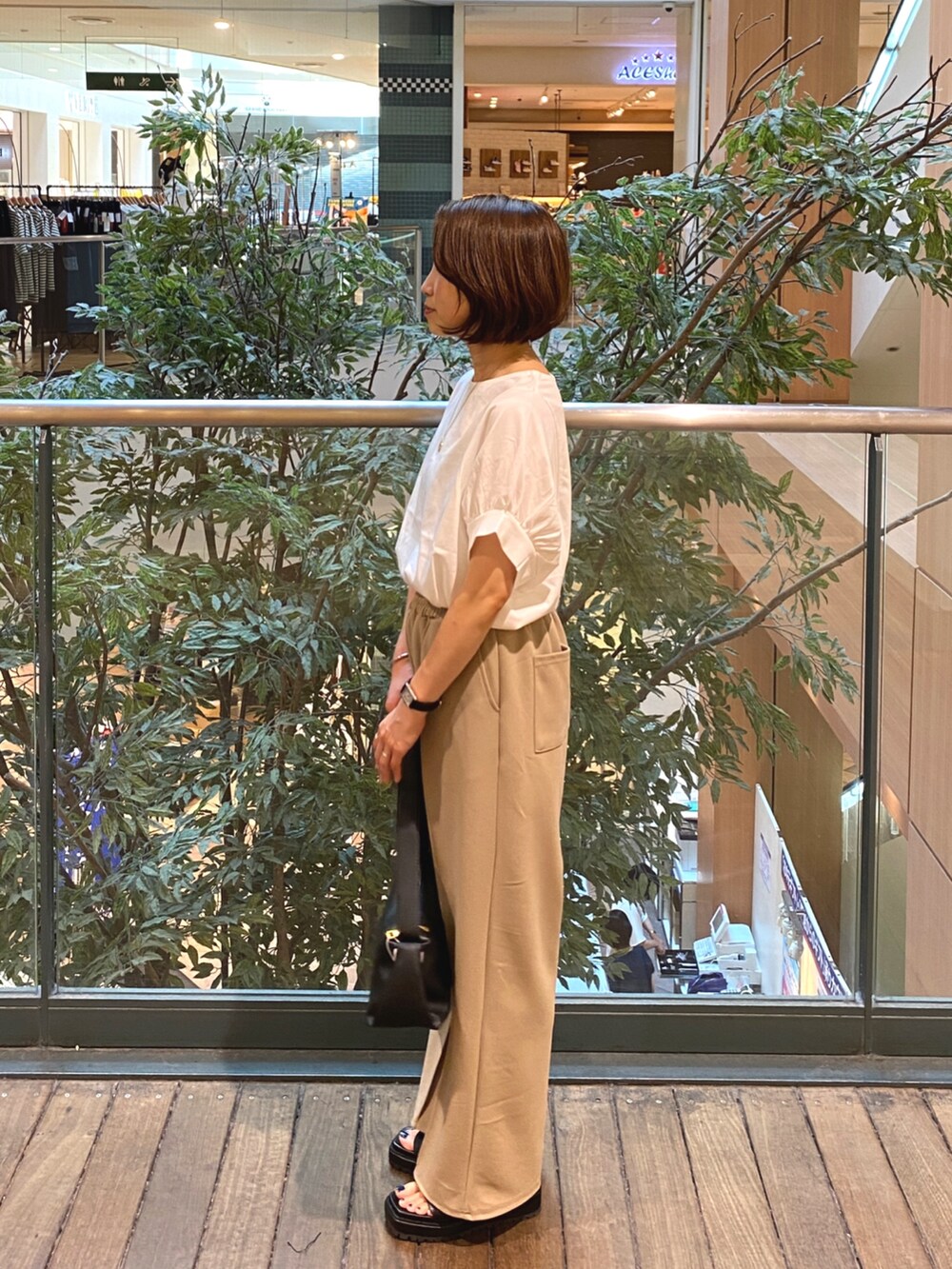 ホワイト系のTシャツ/カットソー、ブラック系のその他パンツ、ブラック系のショルダーバッグを着用したレディースの夏コーディネートの3枚目の写真