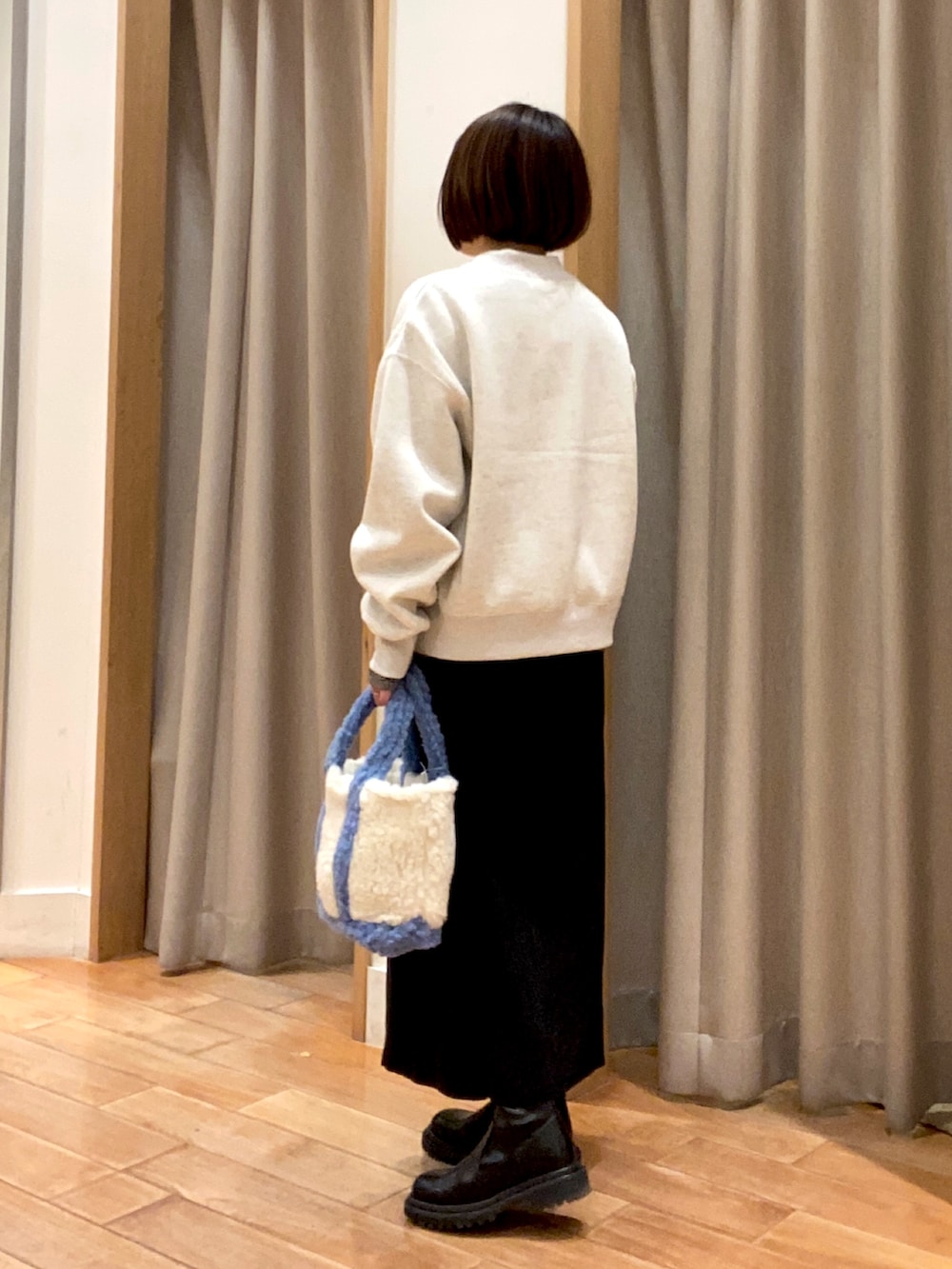 グレー系のスウェット、ブラック系のTシャツ/カットソー、ブラック系のスカートを着用したレディースの冬コーディネートの5枚目の写真