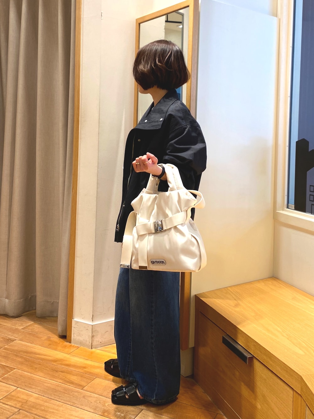 ブルー系のデニムパンツ、ブルー系のTシャツ/カットソー、ホワイト系のショルダーバッグを着用したレディースの春コーディネートの3枚目の写真