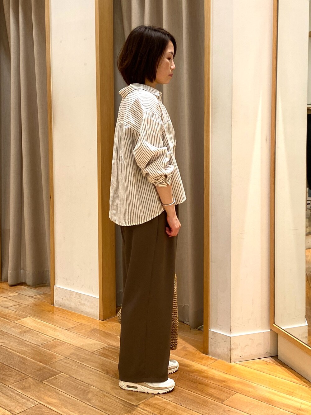 ブラウン系のその他パンツ、ベージュ系のトートバッグ、ベージュ系のシャツ/ブラウスを着用したレディースの春コーディネートの7枚目の写真