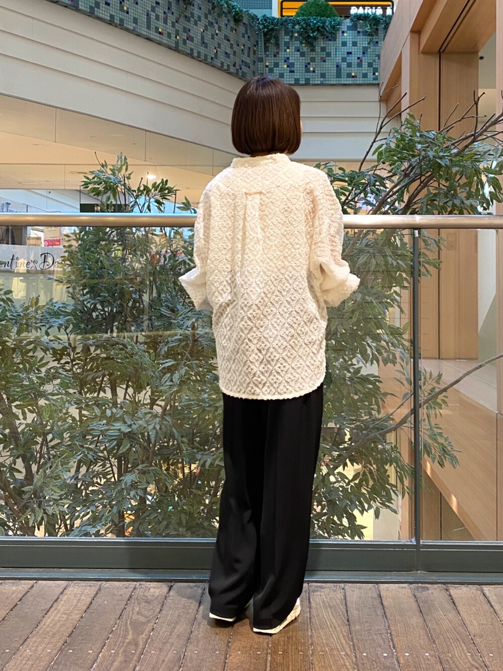ホワイト系のシャツ/ブラウス、ブラック系のスラックス、ブラウン系のハンドバッグを着用したレディースの冬コーディネートの5枚目の写真