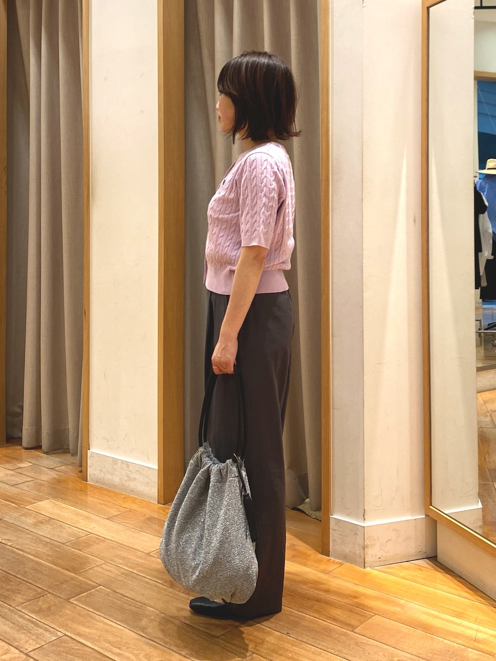 シルバー系のトートバッグ、グレー系のスラックス、パープル系のカーディガン/ボレロを着用したレディースの春コーディネートの6枚目の写真