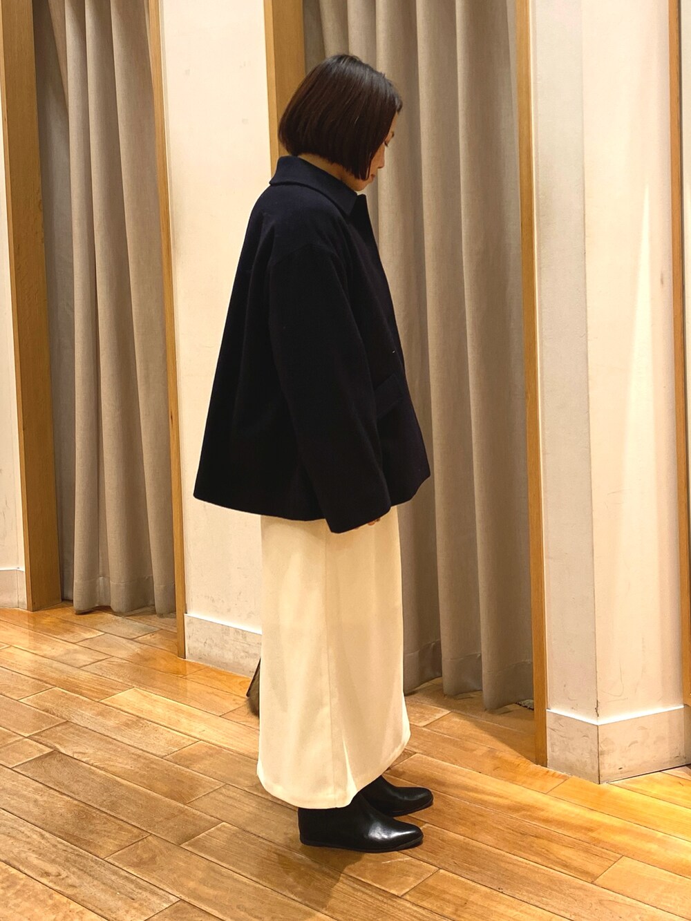 ブルー系のダッフルコート、ブラウン系のニット/セーター、ホワイト系のTシャツ/カットソーを着用したレディースの冬コーディネートの5枚目の写真