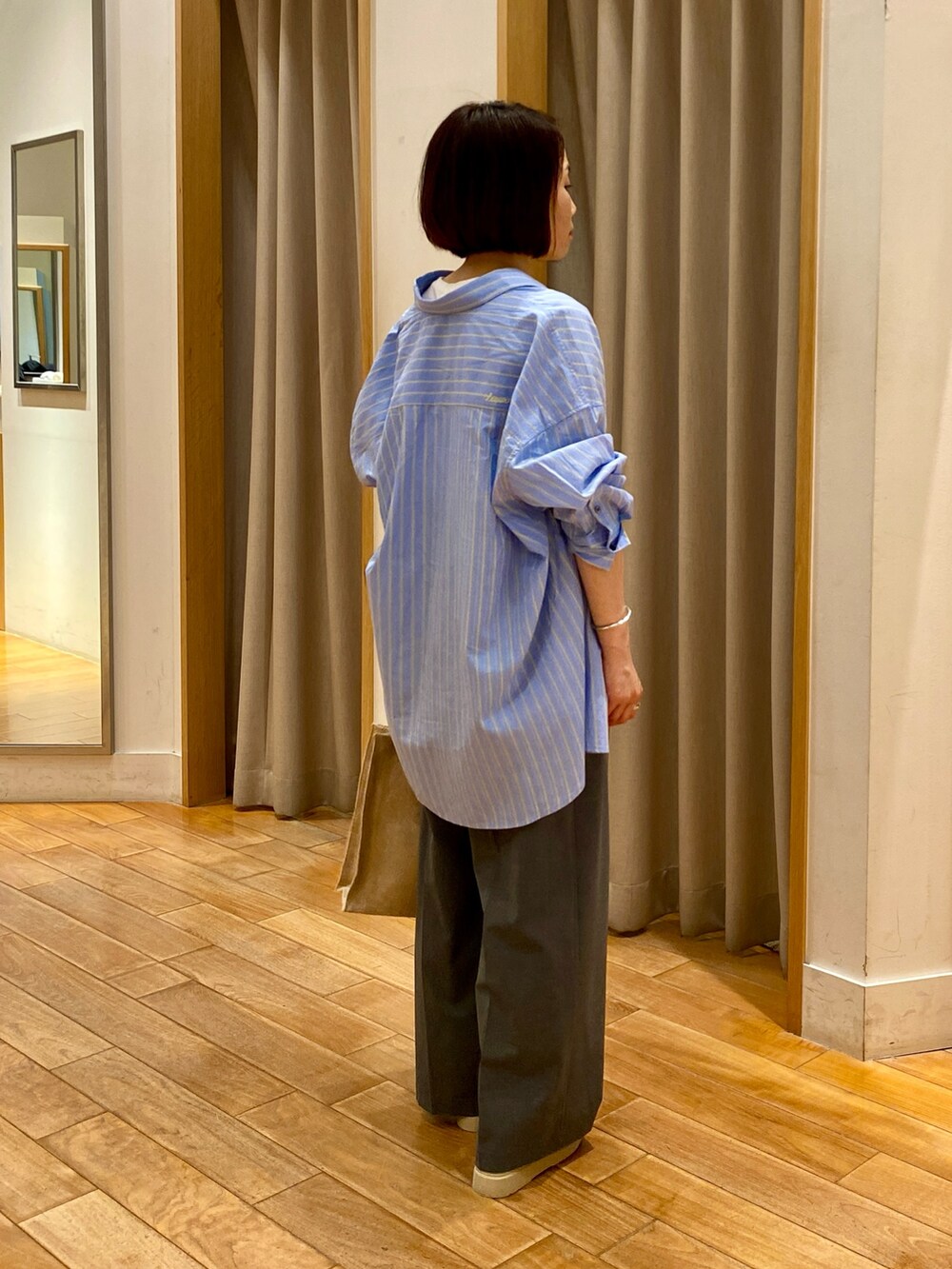 グレー系のスラックス、ホワイト系のタンクトップ、ブルー系のシャツ/ブラウスを着用したレディースの夏コーディネートの6枚目の写真