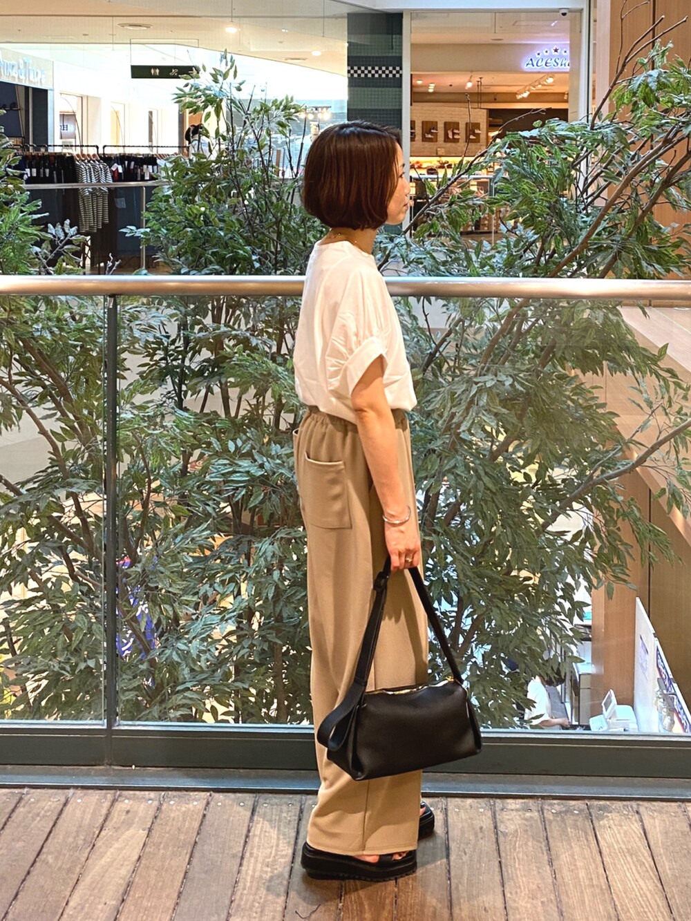 ホワイト系のTシャツ/カットソー、ブラック系のその他パンツ、ブラック系のショルダーバッグを着用したレディースの夏コーディネートの4枚目の写真