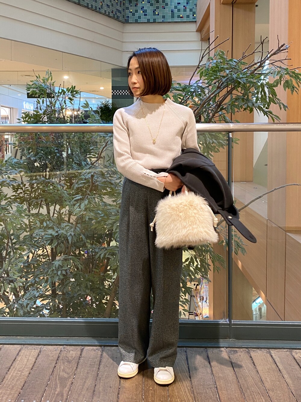 グレー系のピーコート、ホワイト系のその他トップス、グレー系のスラックスを着用したレディースの冬コーディネートの5枚目の写真