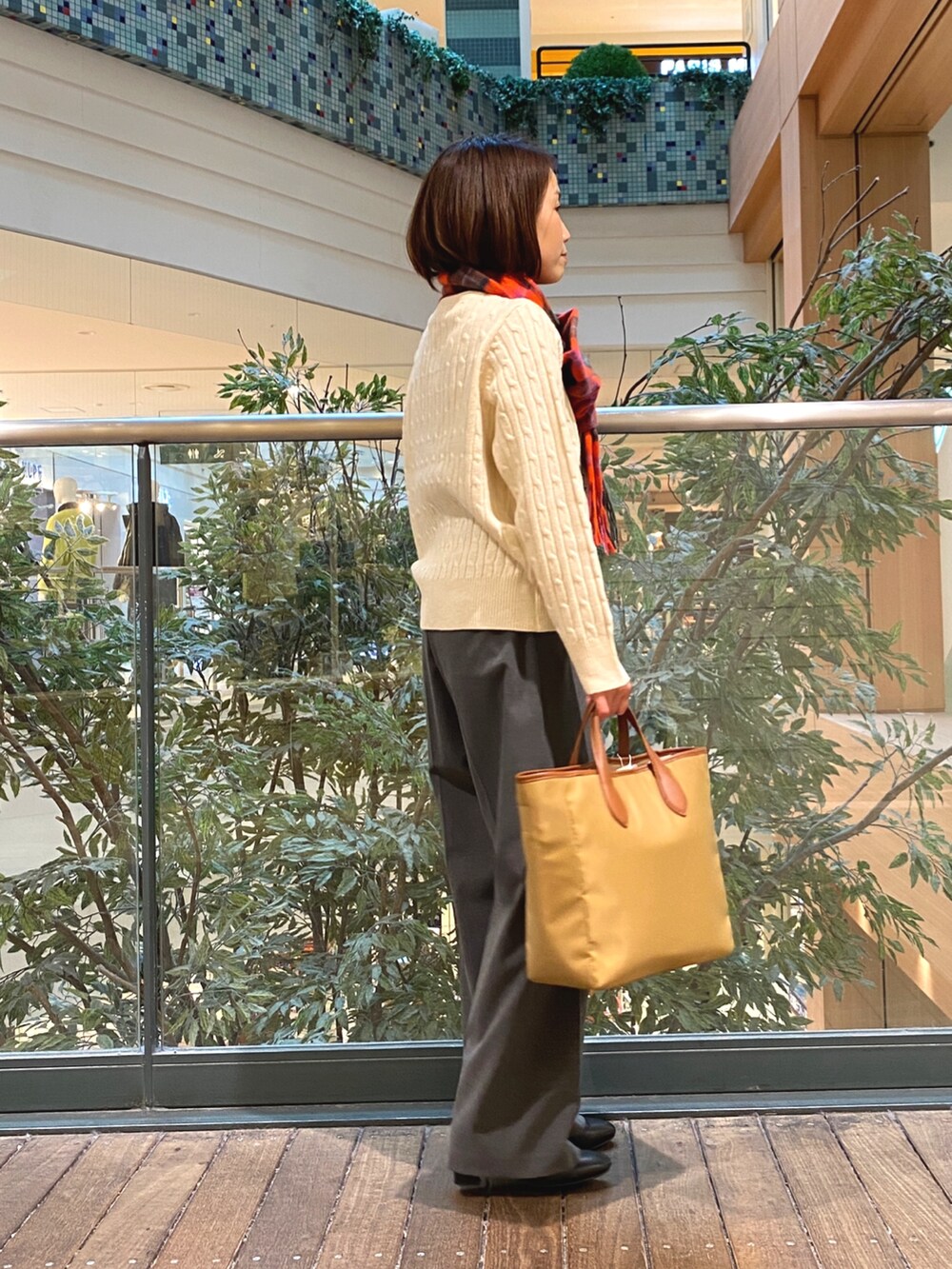 ホワイト系のニット/セーター、グレー系のその他パンツ、イエロー系のショルダーバッグを着用したレディースの秋コーディネートの4枚目の写真