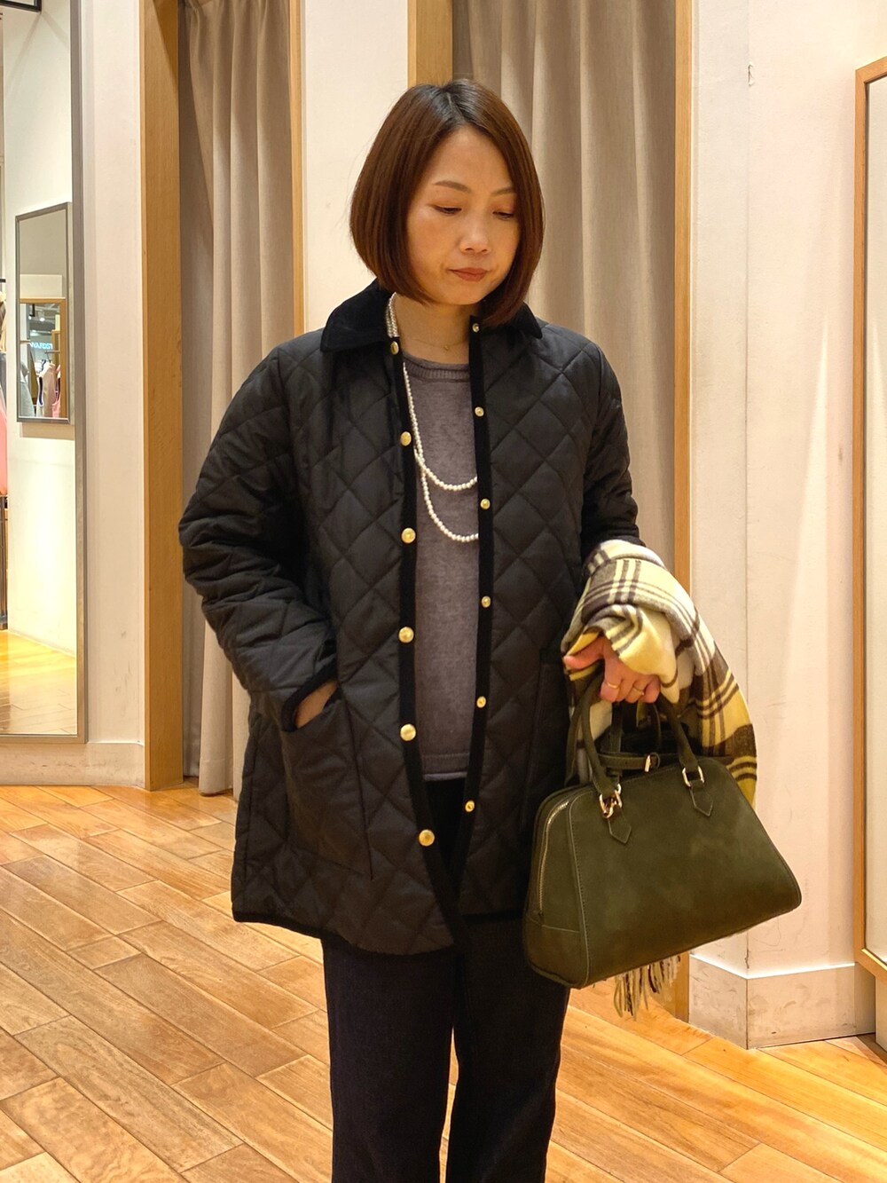 ブルー系のデニムパンツ、ブラック系のブルゾン、グリーン系のショルダーバッグを着用したレディースの秋コーディネートの3枚目の写真