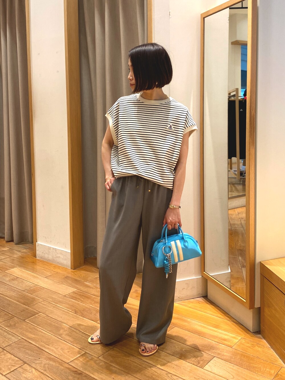 グレー系のその他パンツ、ブルー系のボストンバッグ、ホワイト系のTシャツ/カットソーを着用したレディースの春コーディネートの2枚目の写真