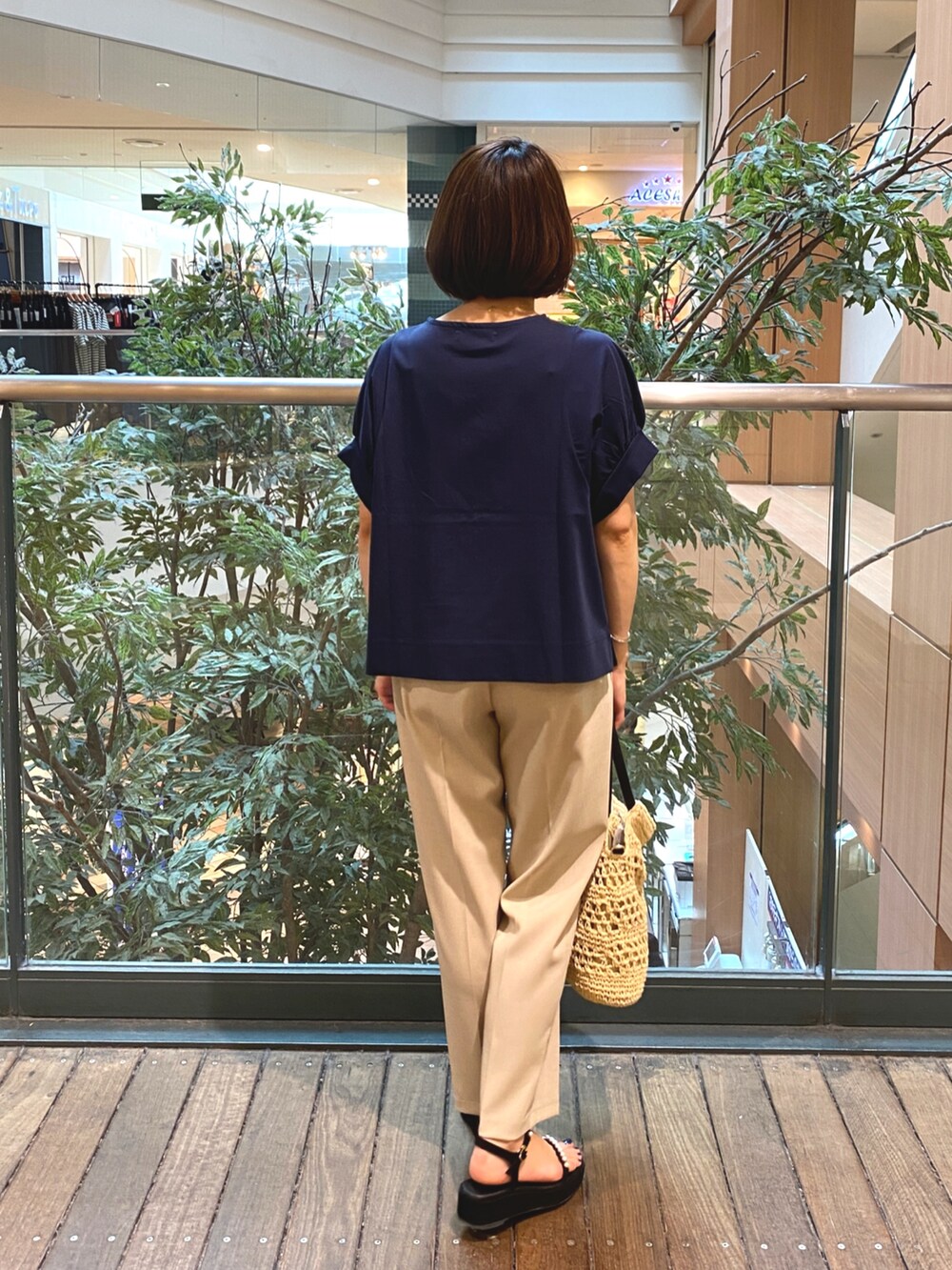 ブルー系のTシャツ/カットソー、ベージュ系のかごバッグ、ベージュ系のその他パンツを着用したレディースの夏コーディネートの7枚目の写真