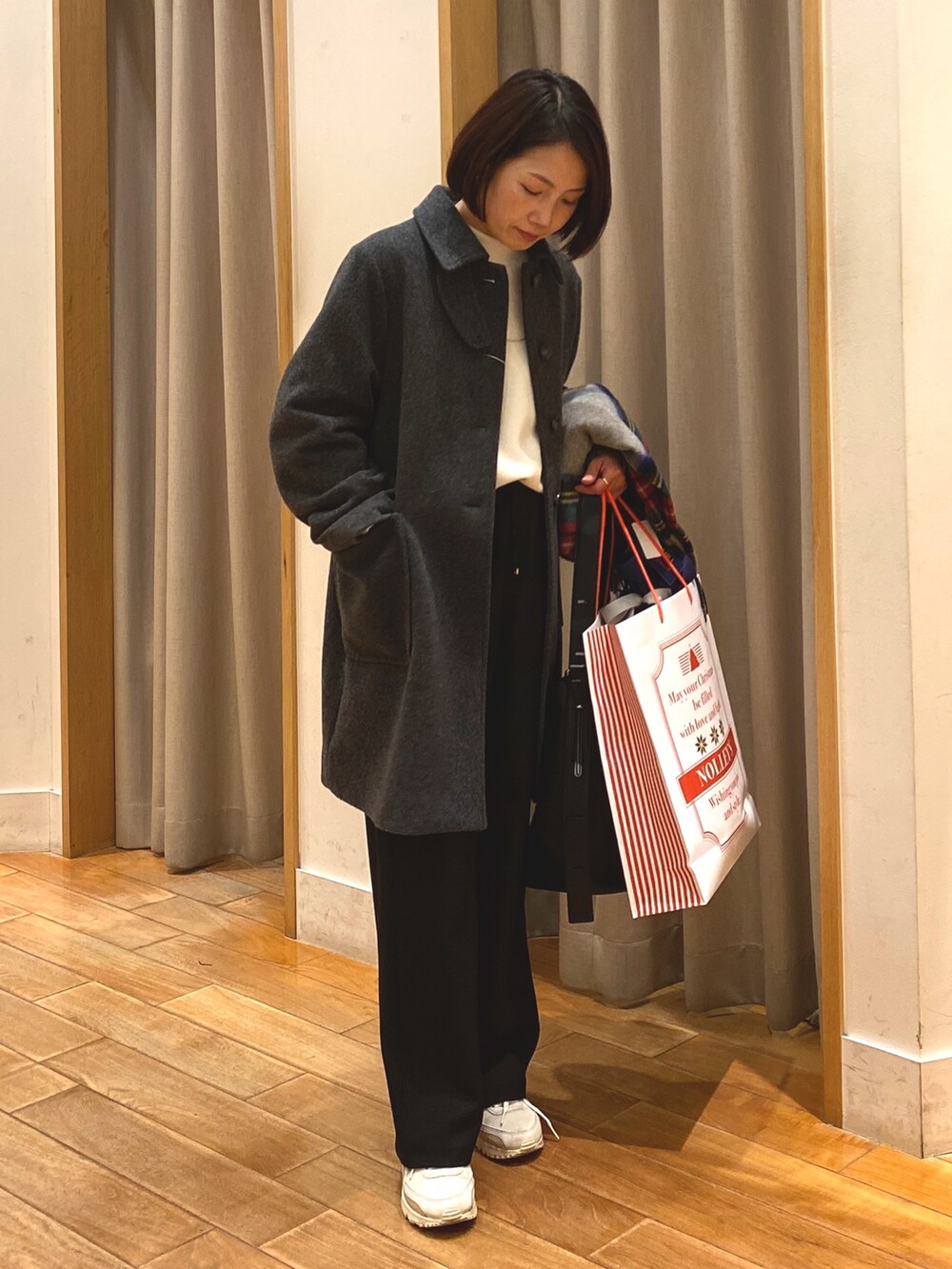 グレー系のダッフルコート、ホワイト系のTシャツ/カットソー、ブラック系のその他パンツを着用したレディースの冬コーディネートの2枚目の写真
