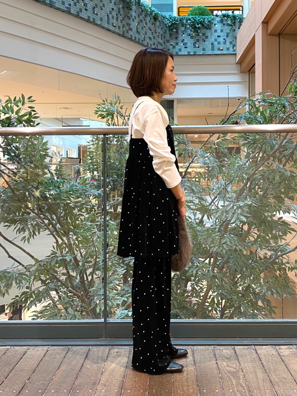 ブラック系のキャミソール、ホワイト系のTシャツ/カットソー、グレー系のハンドバッグを着用したレディースの秋コーディネートの3枚目の写真