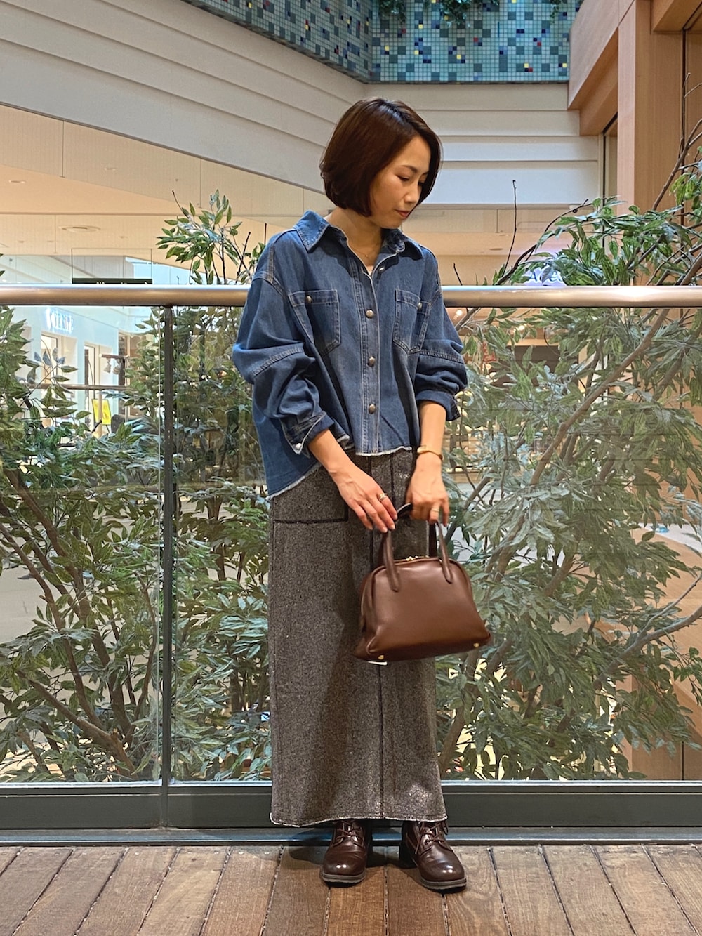 ブルー系のシャツ/ブラウス、グレー系のスカート、ホワイト系のTシャツ/カットソーを着用したレディースの秋コーディネートの2枚目の写真