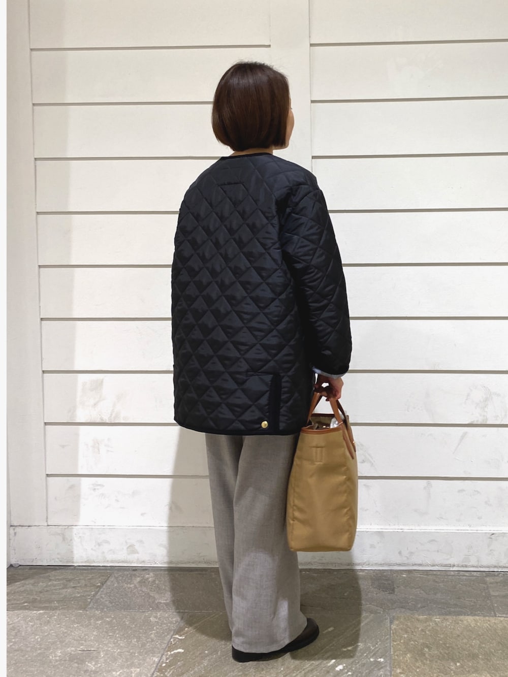 ブラック系のブルゾン、ホワイト系のTシャツ/カットソー、イエロー系のショルダーバッグを着用したレディースの秋コーディネートの5枚目の写真