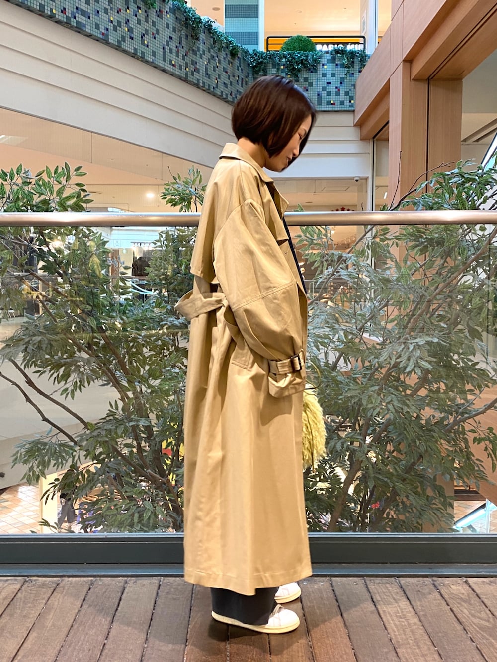 ベージュ系のトレンチコート、ブルー系のニット/セーター、グレー系のその他パンツを着用したレディースの秋コーディネートの3枚目の写真