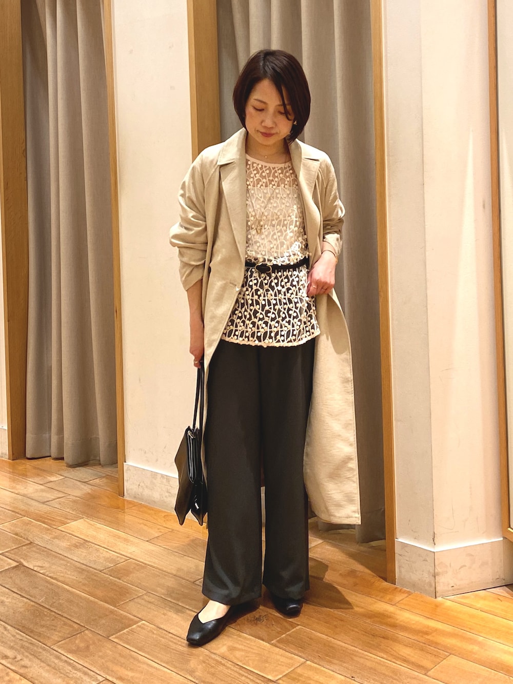 ホワイト系のシャツ/ブラウス、ベージュ系のトレンチコート、グレー系のその他パンツを着用したレディースの春コーディネートの2枚目の写真