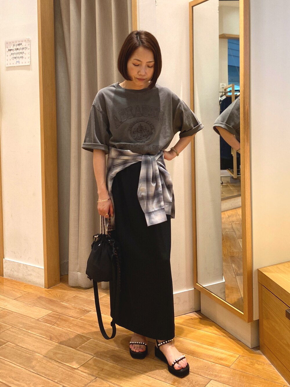 グレー系のシャツ/ブラウス、ブラック系のスカート、ブラック系のショルダーバッグを着用したレディースの夏コーディネートの2枚目の写真